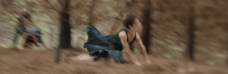 Imaxe dos ensaios da peza Vacuo na que se ven, difuminadas, dúas bailarinas nun bosque.
