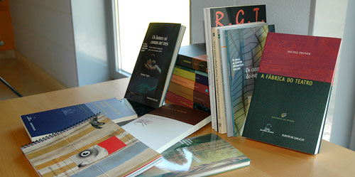 Fotografía na que poden verse varios libros publicados pola Agadic, colocados sobre unha mesa de madeira
